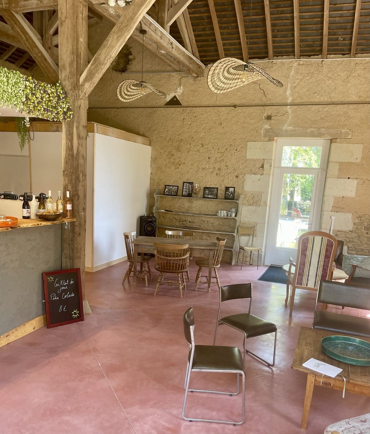 La salle du Garage : charpente apparente, murs en pierre et bar